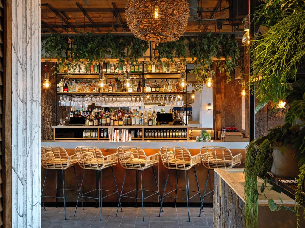 a bar with wicker chairs and a bar counter at Treehouse Hotel London in London
