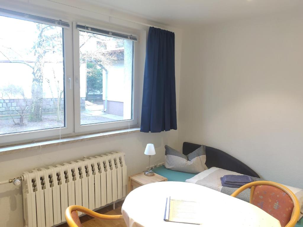 Habitación con 1 cama, 1 mesa y 2 ventanas en FeWo in Köpenick en Berlín