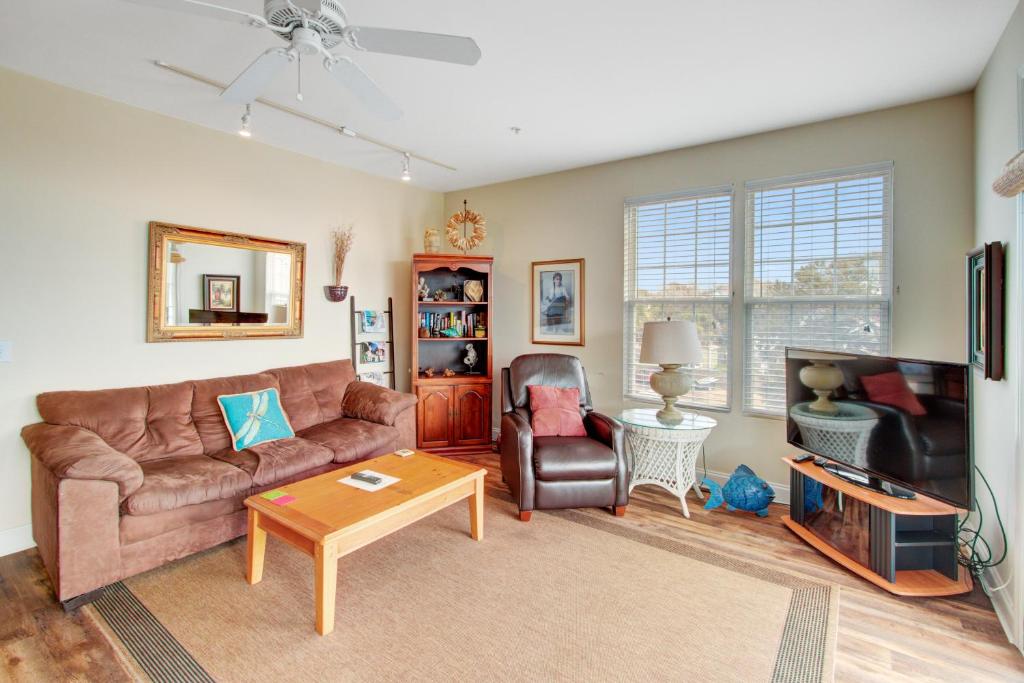 a living room with a couch and a tv at Beachwalk Villas 23 in Folly Beach
