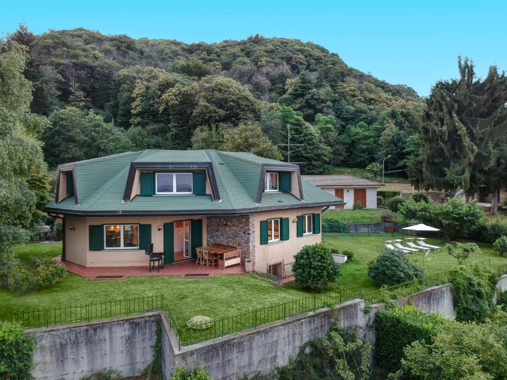 una casa con techo verde en la parte superior de un patio en Villa Regina Bella by Casa da Suite, en Nebbiuno