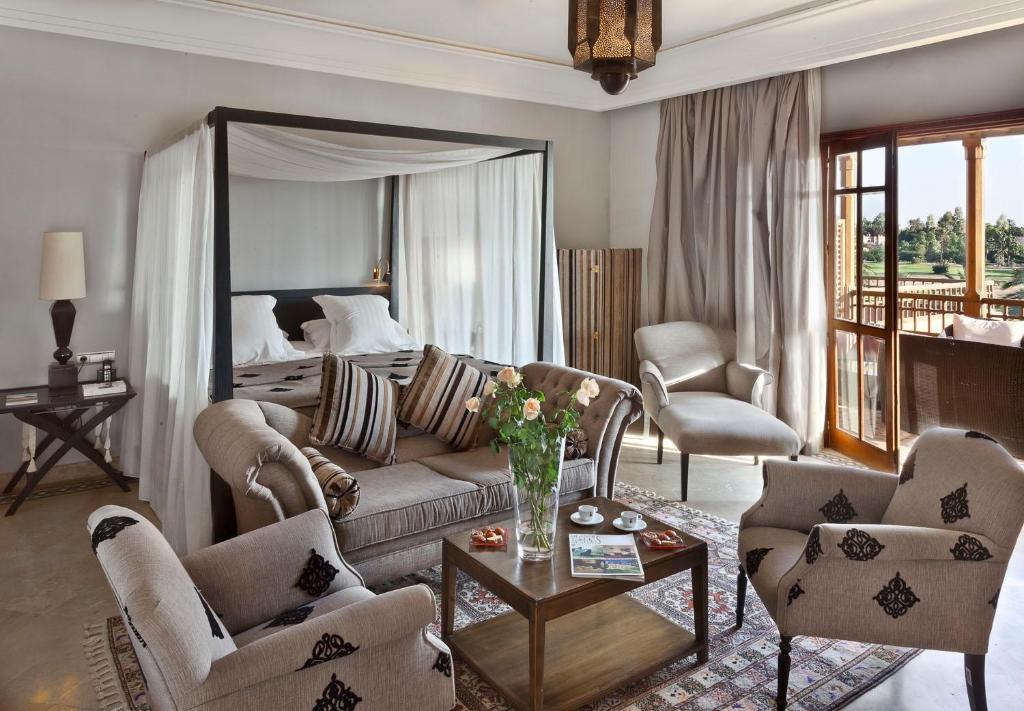 a living room with a couch and chairs and a bed at Golf Club Rotana Palmeraie in Marrakech