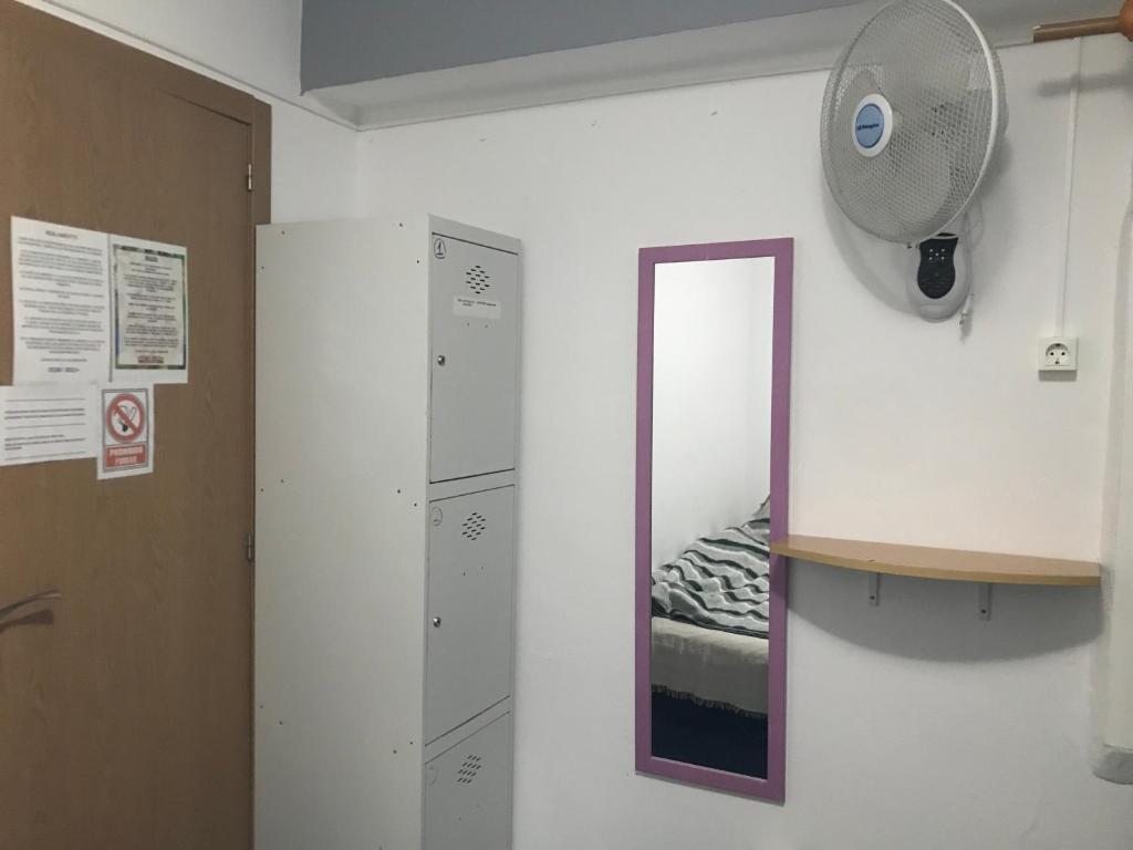 Zimmer mit einem Wandspiegel und einem Ventilator in der Unterkunft Ceibo Ibiza - Guest House in Ibiza-Stadt