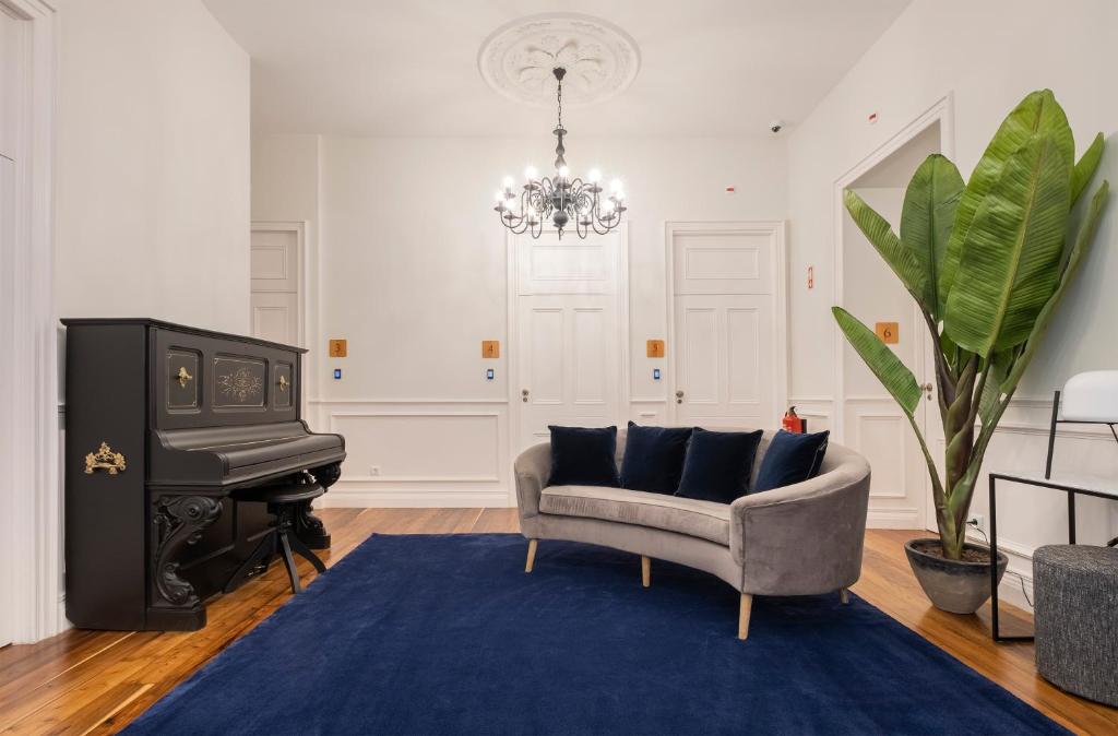 a living room with a couch and a piano at CASA DA GRAÇA in Ponta Delgada