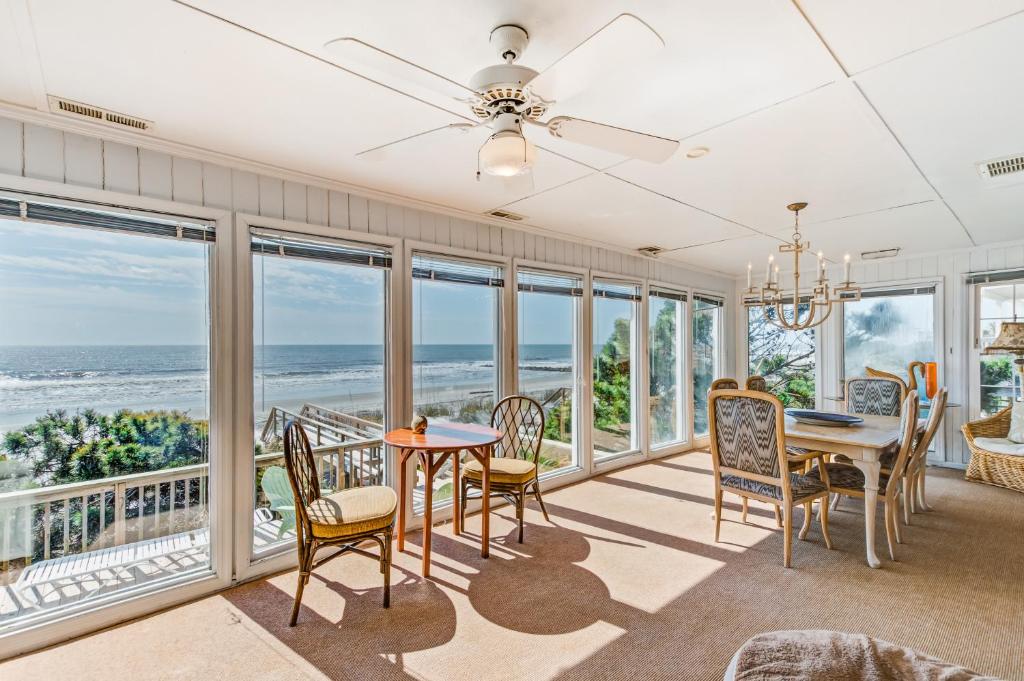 a dining room with a view of the ocean at Clervue Cottage in Folly Beach