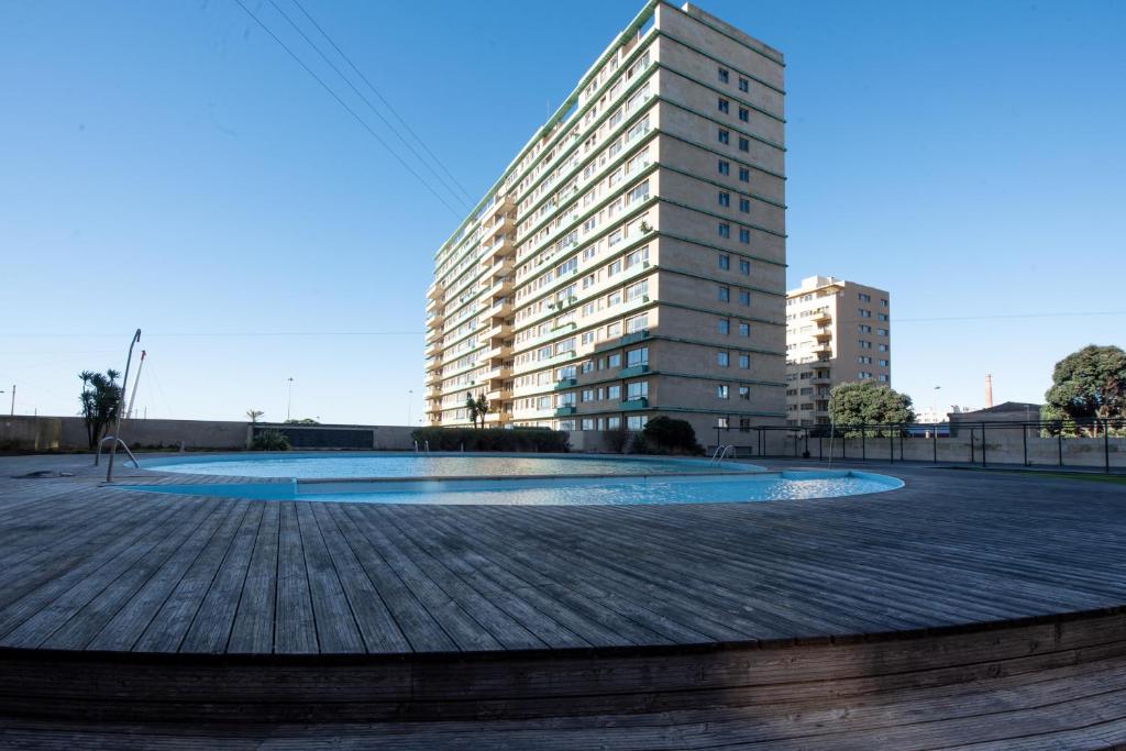 a building with a large pool in the middle of a city at Apartamento Portas do Mar I in Matosinhos