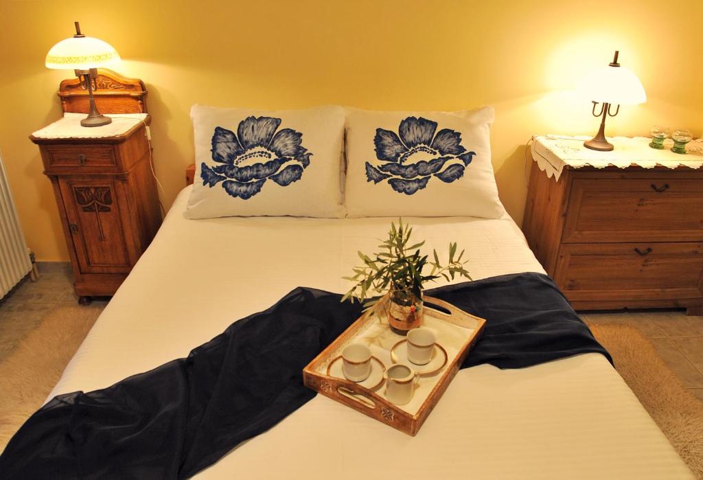 a bed with a tray with two cups and a plant on it at Studio Maistros in Galaxidi