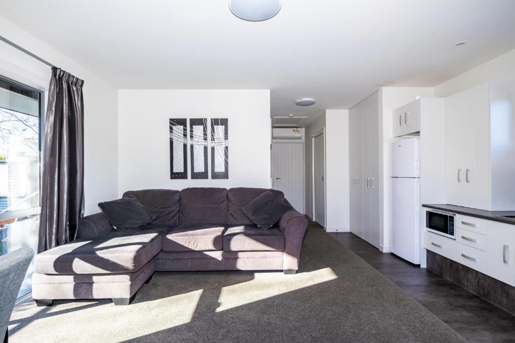 a living room with a couch and a kitchen at Black on Grey in Geraldine