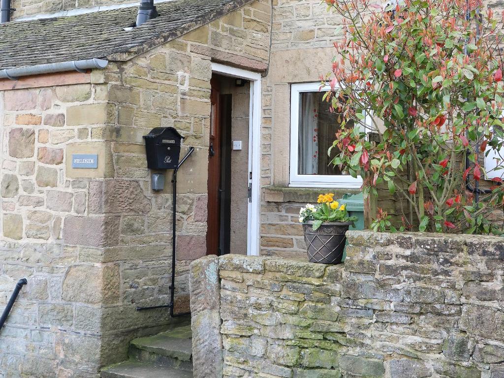 a stone house with a door and a potted plant at Fieldside in Belper