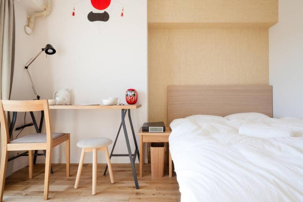 a bedroom with a bed and a desk and a chair at Dwell Urban 6C in Tokyo