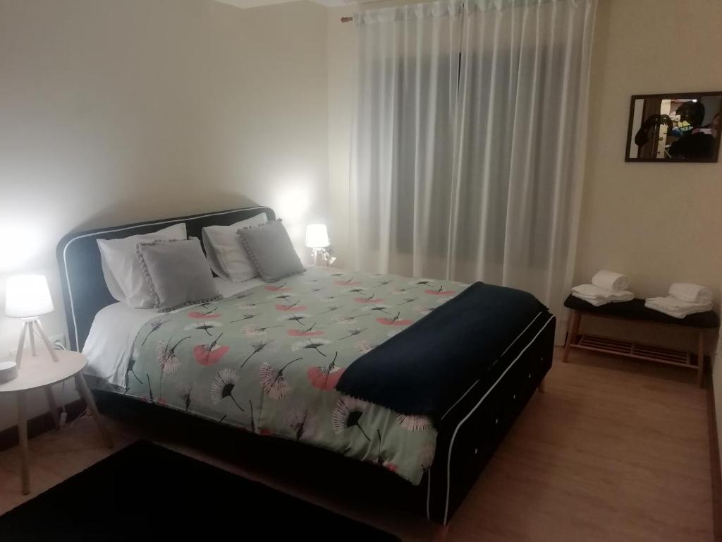 um quarto com uma cama com um edredão floral em Sailorman House em Aveiro