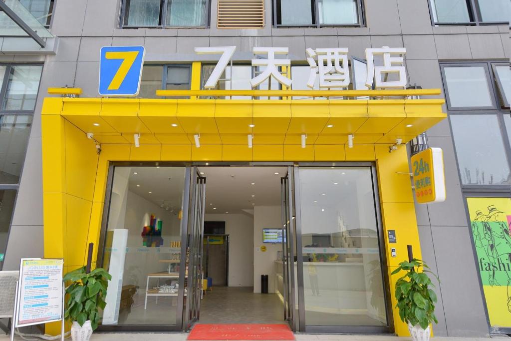 un ingresso giallo a un edificio con porta di 7 Days Guiyang Century City Convention and Exhibition City a Guiyang