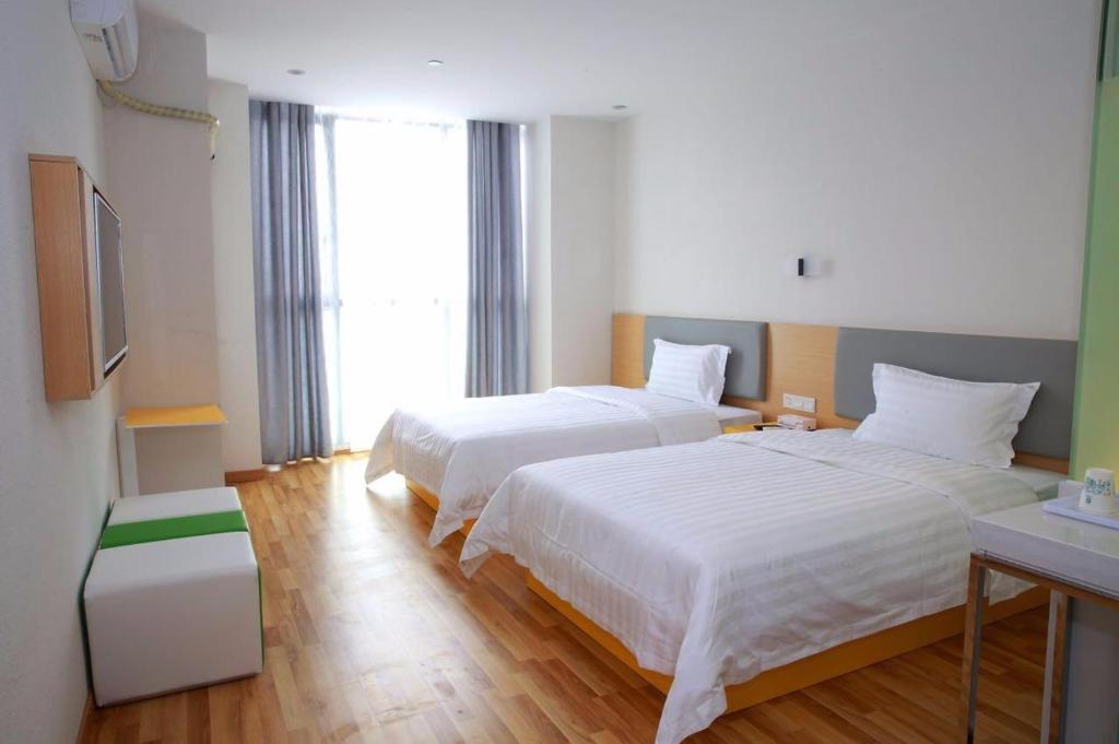 貴陽的住宿－7天酒店·贵阳北站店，酒店客房设有两张床和电视。
