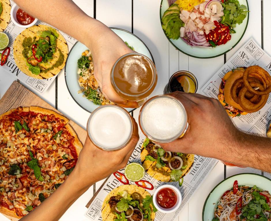 a group of people with glasses of beer and plates of food at Crystalbrook Flynn in Cairns