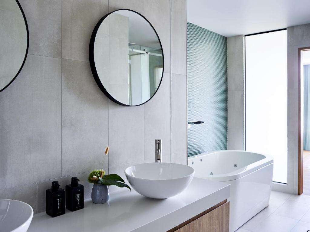 a bathroom with two sinks and a large mirror at Crystalbrook Flynn in Cairns