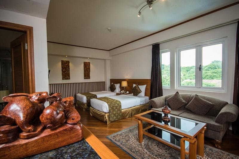 a living room with a bed and a couch at Hotel Shwe Yee in Yangon