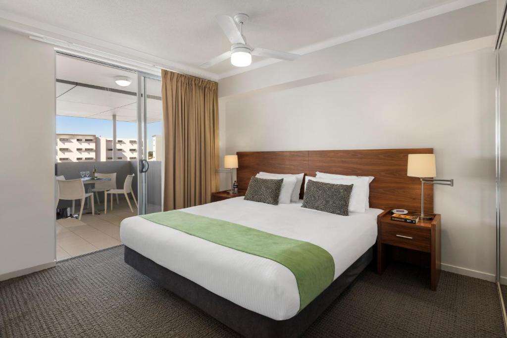 Habitación de hotel con cama y balcón en Quest Chermside, en Brisbane