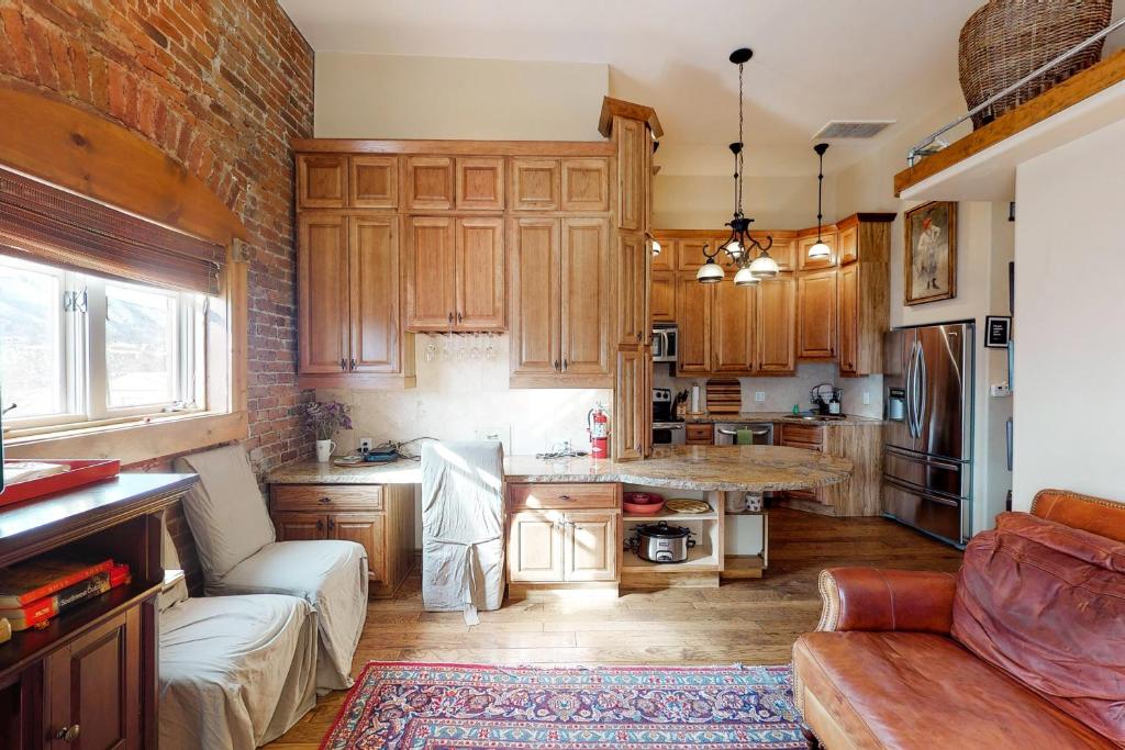 a kitchen with wooden cabinets and a couch in a room at Jarvis #303 in Durango