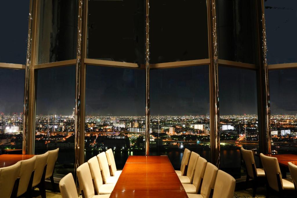 a long table and chairs in a room with a view at Hotel Keihan Universal Tower in Osaka