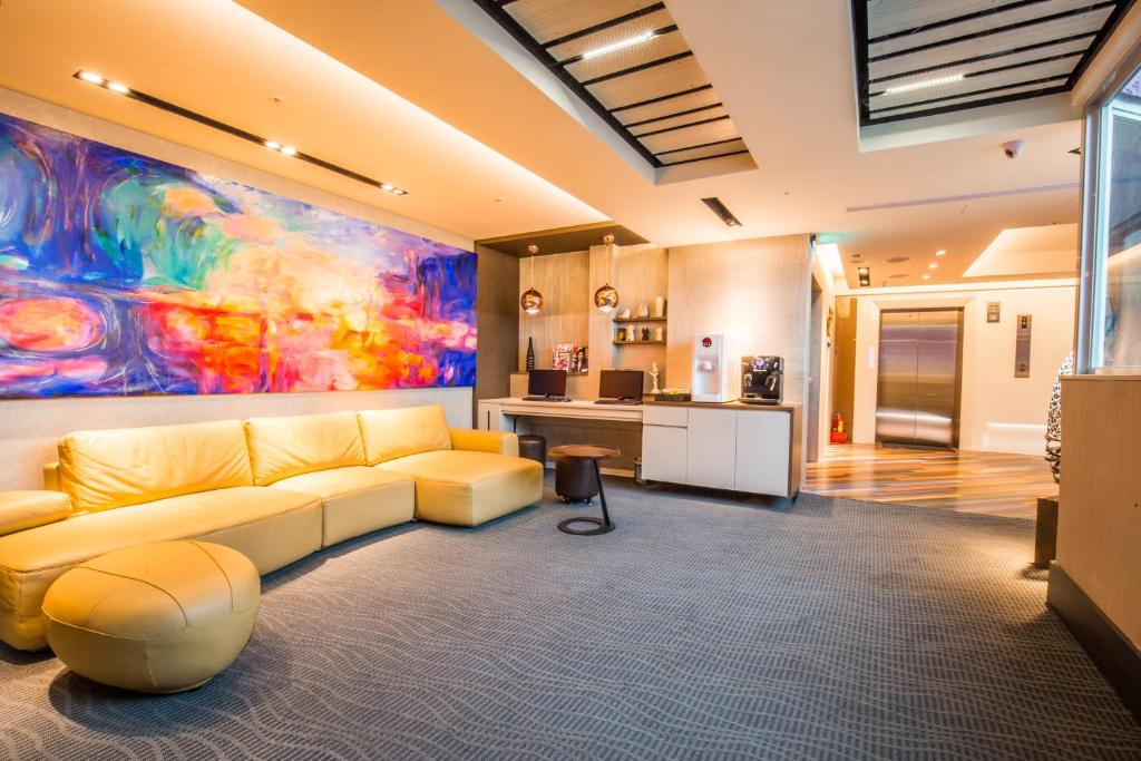 Walker Hotel. Ximen في تايبيه: غرفة معيشة مع أريكة صفراء ولوحة ملونة