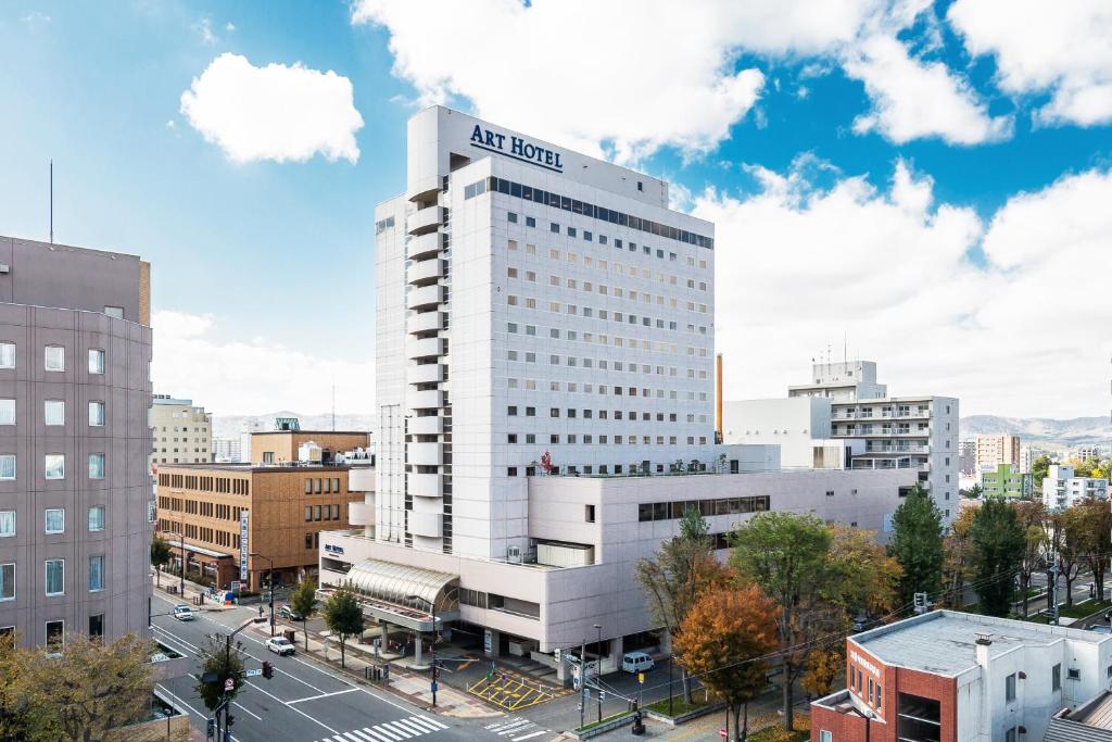 a tall white building with a sign on it at Art Hotel Asahikawa in Asahikawa