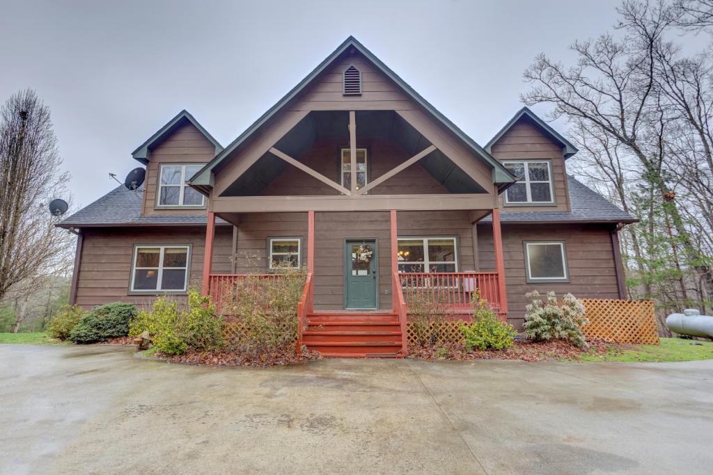 une maison brune avec une terrasse couverte à l'avant rouge dans l'établissement Southern Cross Lodge, à Mineral Bluff