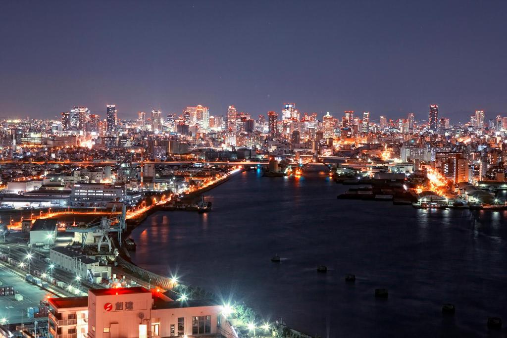 a view of a city at night with a river at Hotel Keihan Universal Tower in Osaka