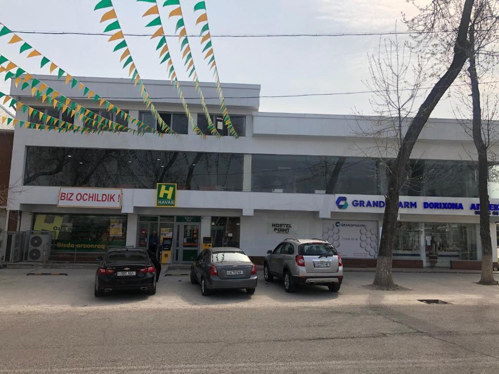 tres coches estacionados frente a una gasolinera en HostelPoint, en Tashkent