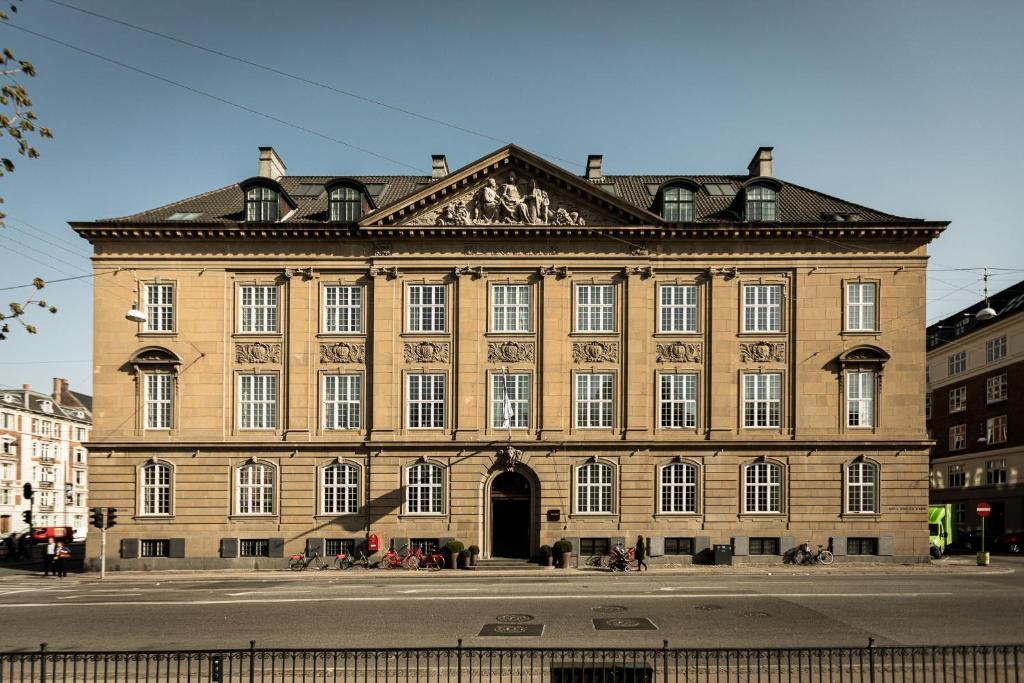 Nobis Hotel Copenhagen, a Member of Design Hotels™ في كوبنهاغن: مبنى من الطوب كبير على شارع المدينة