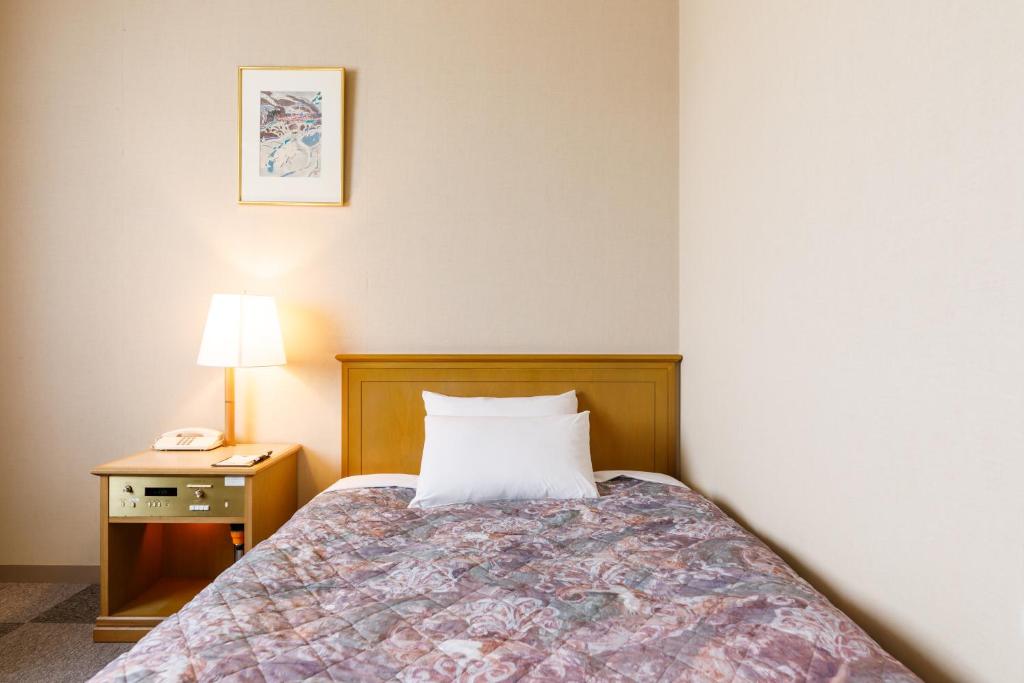 Postel nebo postele na pokoji v ubytování Fukuno Town Hotel A・Mieux