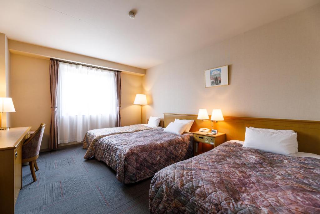 Postel nebo postele na pokoji v ubytování Fukuno Town Hotel A・Mieux