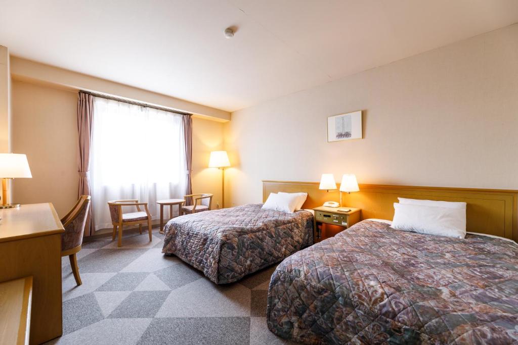 Postel nebo postele na pokoji v ubytování Fukuno Town Hotel A・Mieux