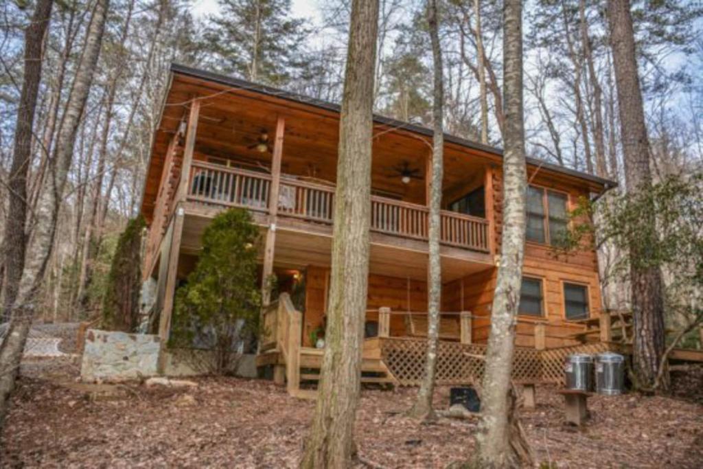 a large log cabin in the woods with trees at Indian Rock Lake in Blue Ridge