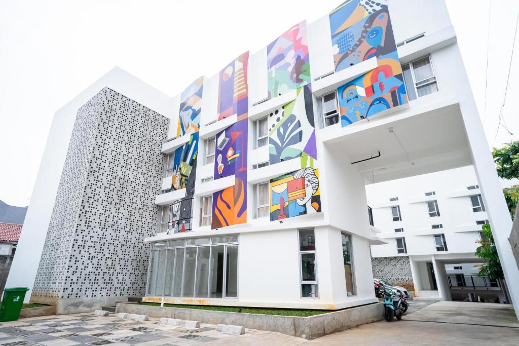 un edificio con un mural en el costado en KoolKost near University of Indonesia 2 - Minimum Stay 2 Nights en Pondoktjing Dua