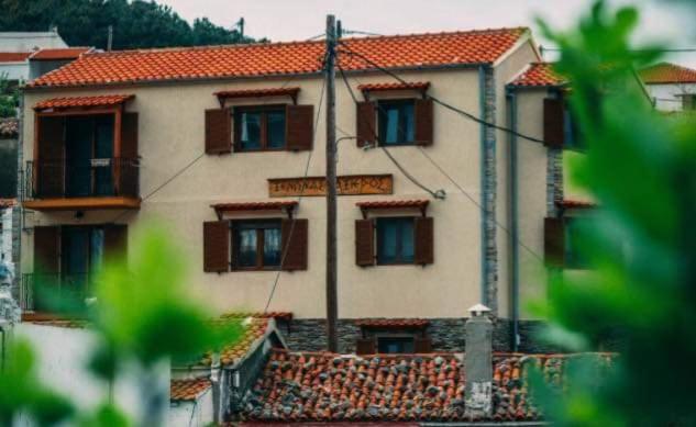 a large building with brown windows and a pole at Guesthouse Axieros in Samothraki