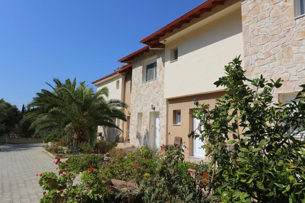 a villa with a palm tree and a building at Melimaria in Pefkohori