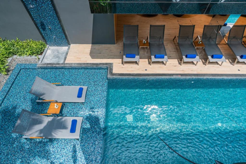 an overhead view of a swimming pool with chairs and a swimming pool at Maven Stylish Hotel Hua Hin in Hua Hin