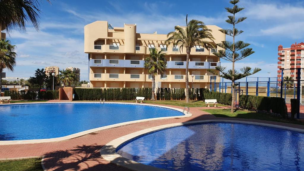 una gran piscina frente a un edificio en Apartamento ÁTICO DREAM Los Miradores del Puerto, en La Manga del Mar Menor
