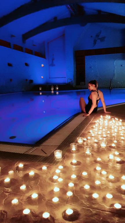 Dimly lit pool area with candles creating a tranquil atmosphere.