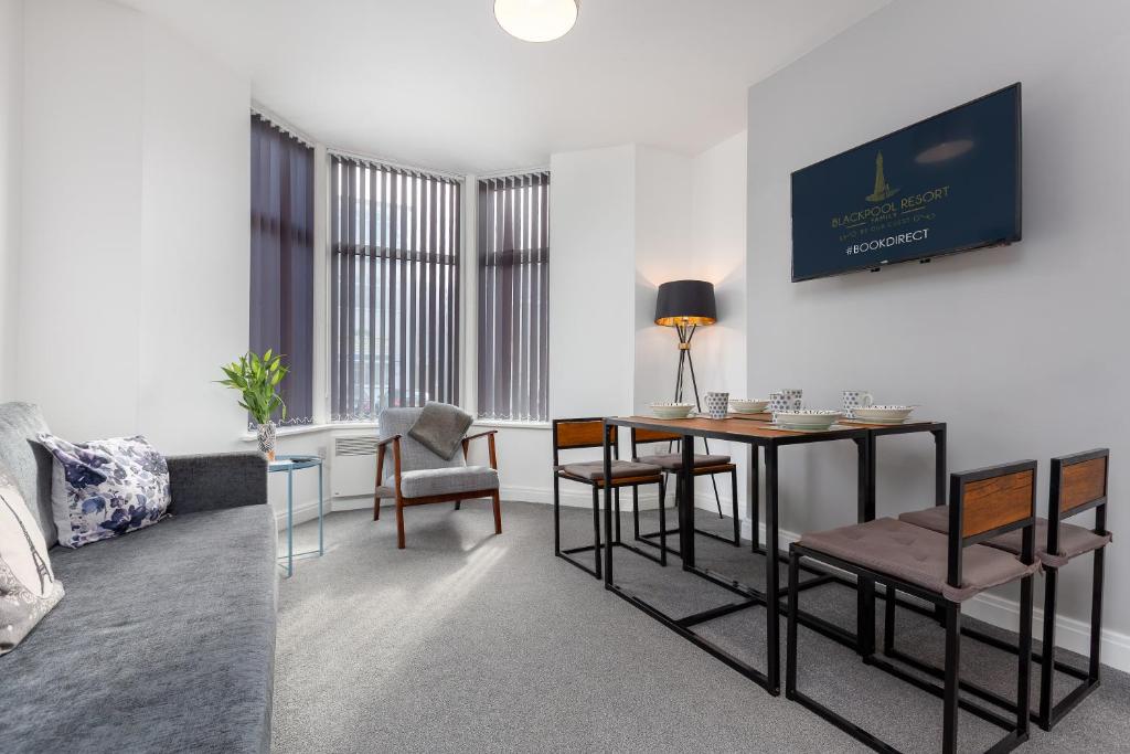 uma sala de estar com mesa e cadeiras em Reads Court Holiday Apartments - Blackpool Resort Collection em Blackpool