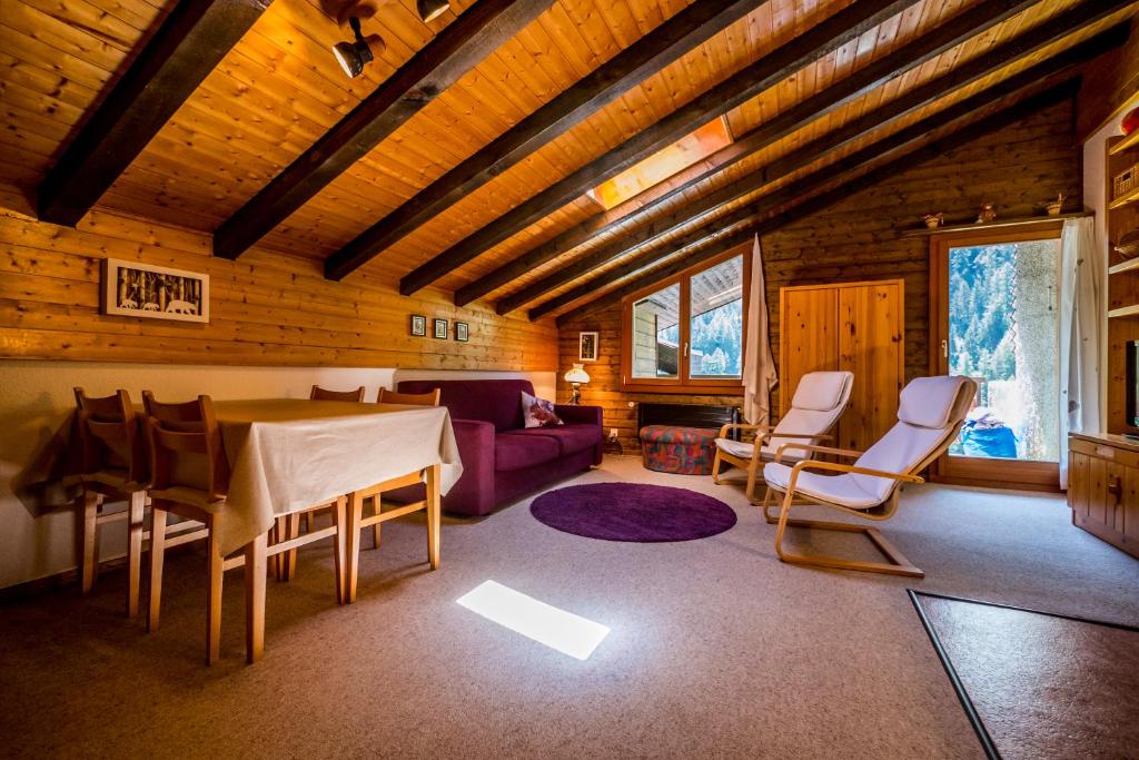 a living room with a table and chairs in a cabin at Appartement cosy au centre de Grimentz in Grimentz