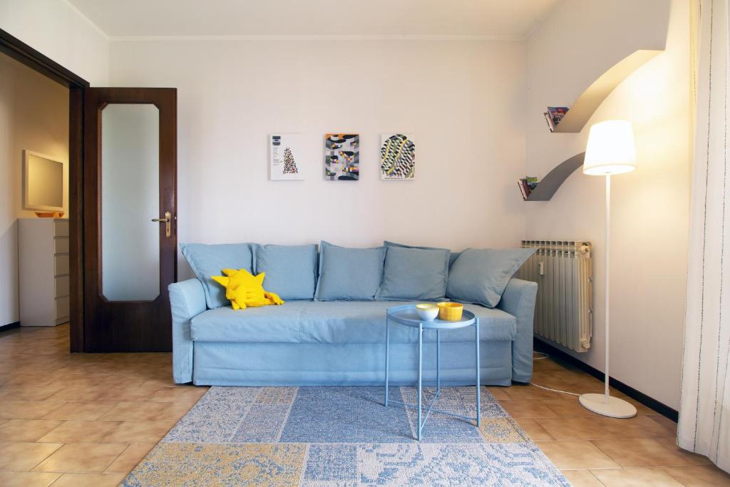 um sofá azul numa sala de estar com uma mesa em Appartamento Ivrea Centro - Sito UNESCO em Ivrea