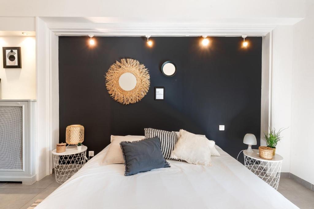 カンヌにあるPlace to beach - Terrasse Bord de mer Croisetteの白い大型ベッドと黒い壁のベッドルーム1室