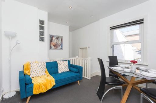 a living room with a blue couch and a table at Derby Street City Centre Preston Aparthotel in Preston