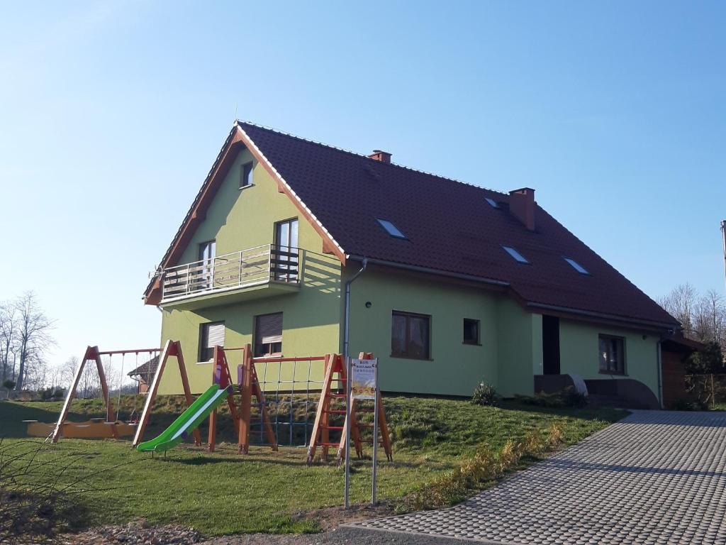 a house with a slide and a playground at Villa ŁĄGI in Bukowiec