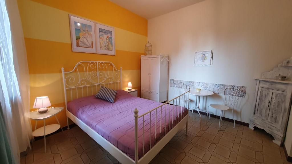 - une chambre avec un lit, deux tables et un réfrigérateur dans l'établissement Cla&Cha Studio, à Bonassola