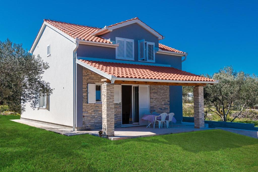 une petite maison avec une pelouse verte dans l'établissement Villa Charm, à Tkon