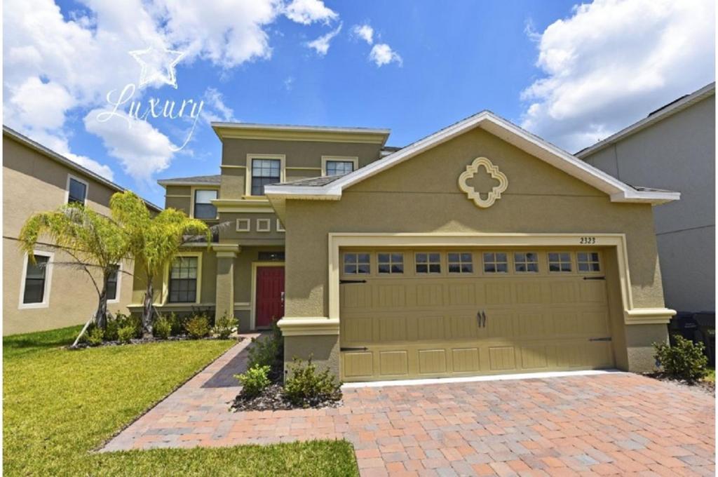 a large house with a garage at Five-Bedroom Pool Home Kissimmee in Orlando