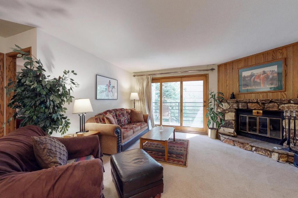 a living room with a couch and a fireplace at Snowdance Manor 205 in Keystone