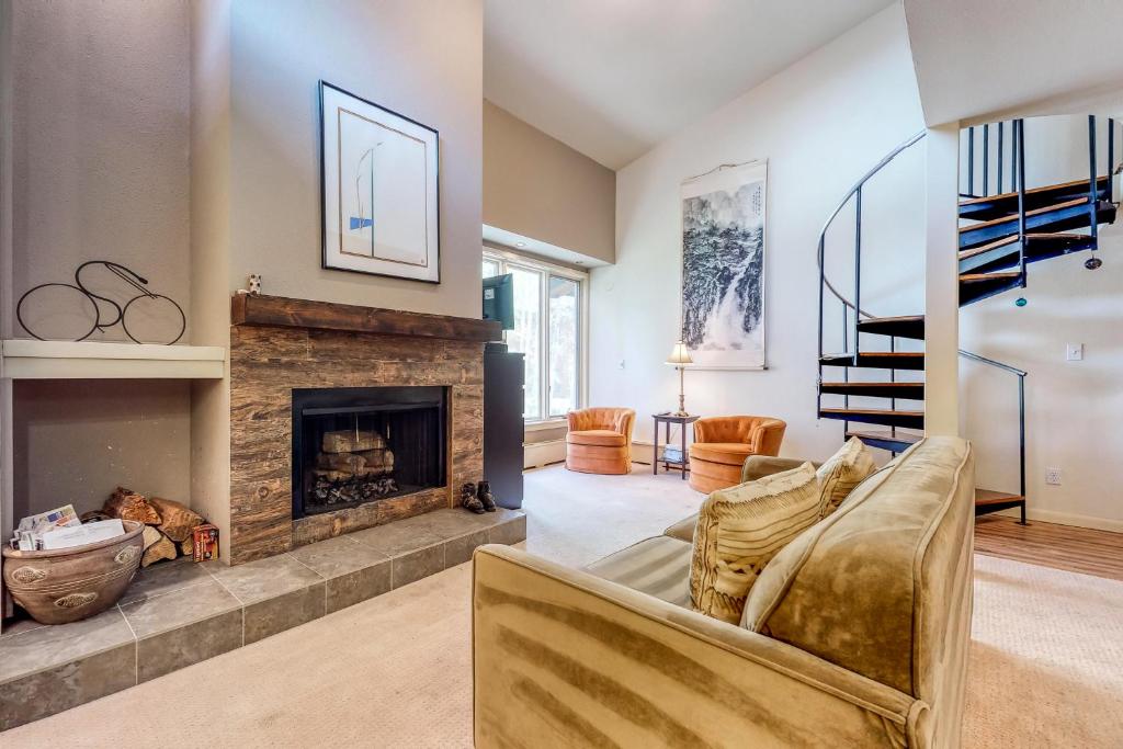 a living room with a couch and a fireplace at Gore Creek Condo in Vail