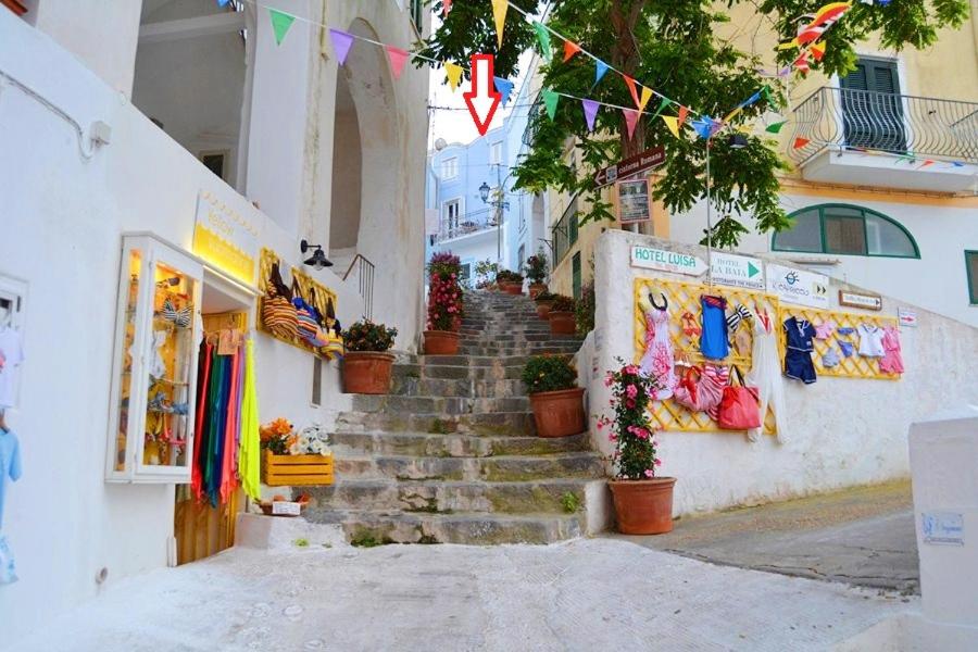 a group of stairs leading up to a building with flags at Maridea - Via Dragonara in Ponza